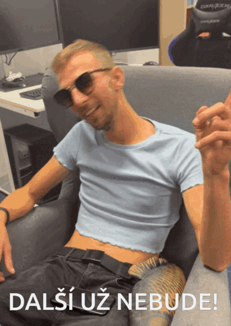 a man in a crop top sits in a chair with the words dalsi uz nebude