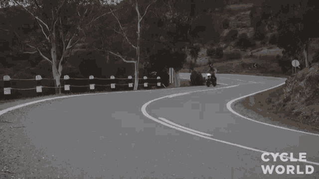 a person riding a motorcycle on a curvy road with the words cycle world visible
