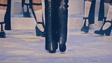a group of people are standing on a stage wearing high heels and socks .