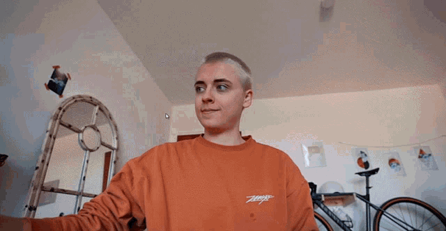 a man wearing an orange sweatshirt with the word ziggy on it