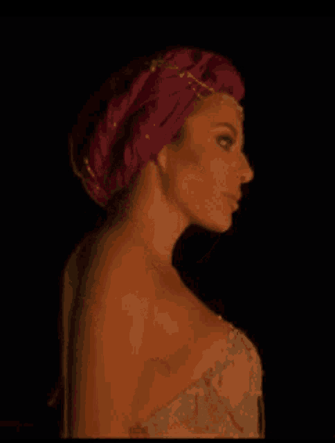 a woman wearing a purple turban and a very revealing dress