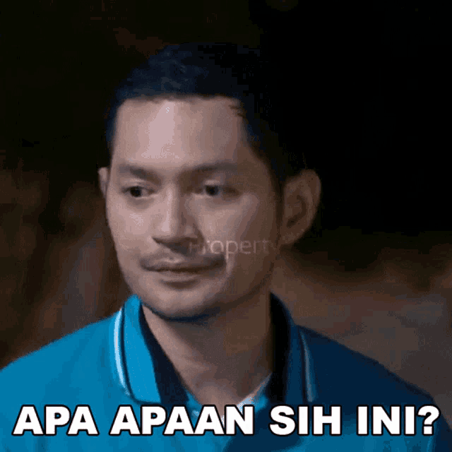 a man in a blue shirt has the words apa apaan sih ini on his face