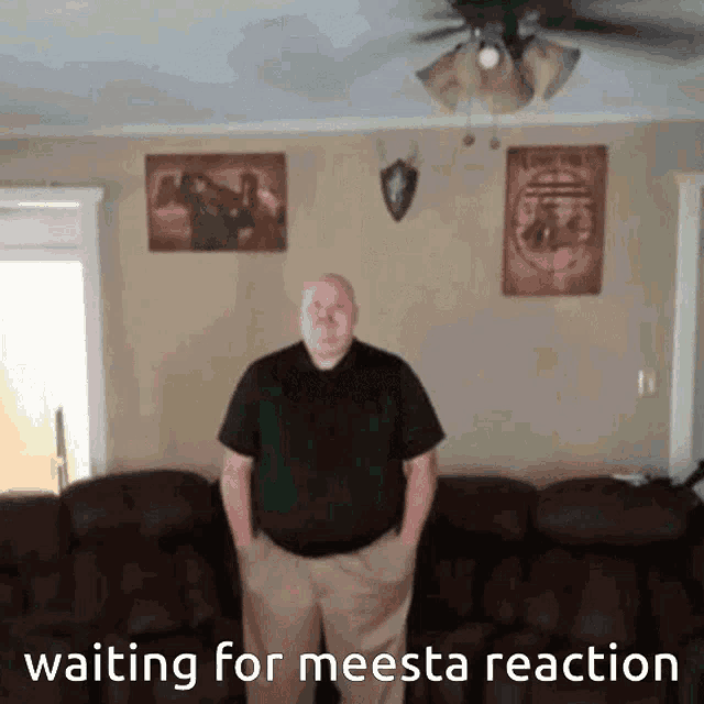 a man standing in front of a couch with the words " waiting for meesta reaction " below him