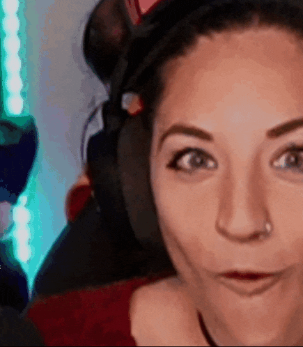 a close up of a woman wearing headphones and making a funny face