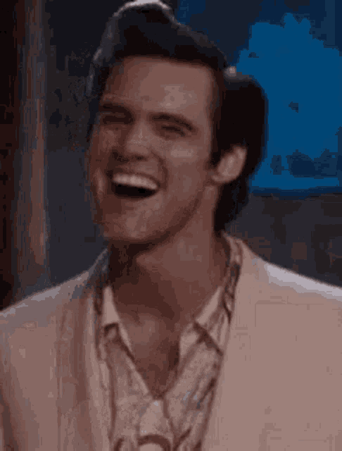 a man in a suit and tie is laughing .
