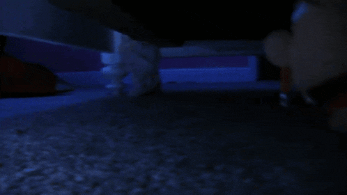a person standing in a dark room with a blue light shining on them