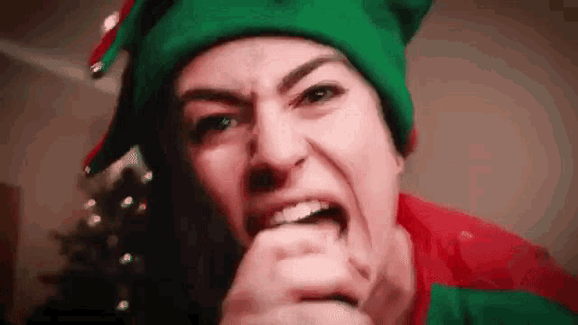 a woman dressed as an elf is making a funny face .