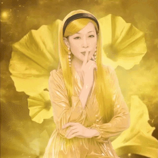 a woman in a yellow dress is holding her finger to her mouth