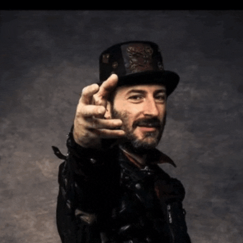 a man with a beard wearing a top hat and a leather jacket