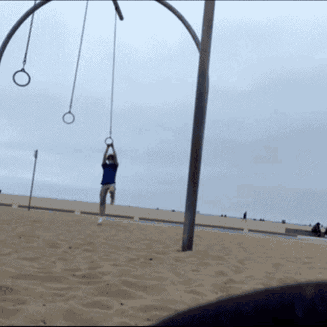 a person is hanging from a rope on a playground