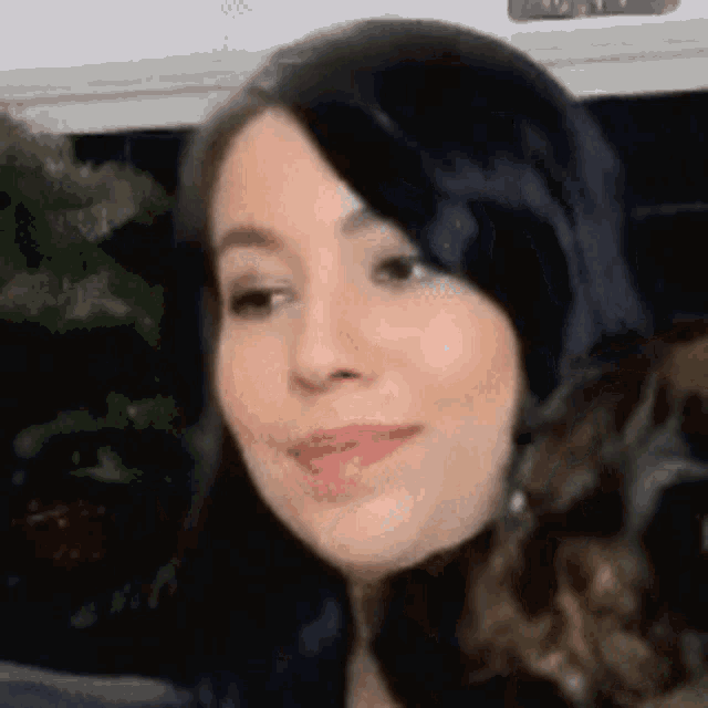 a close up of a woman 's face with black hair looking at the camera .