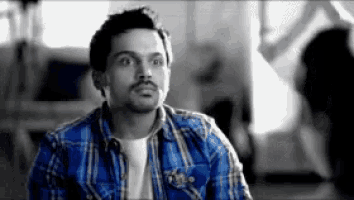 a man in a blue plaid shirt is looking up