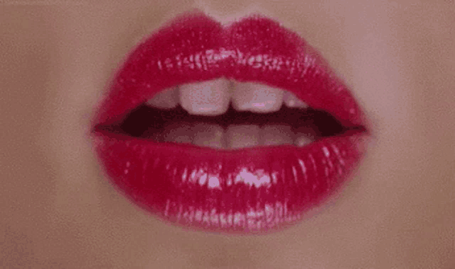 a close up of a woman 's mouth with red lips and white teeth .