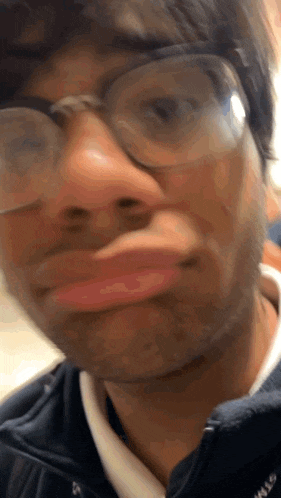 a man wearing glasses making a funny face with his mouth open