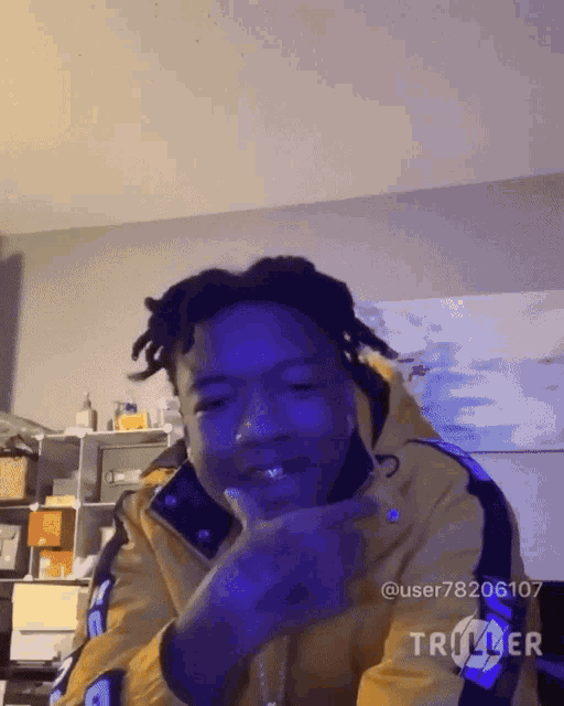 a man wearing a yellow jacket is giving a middle finger