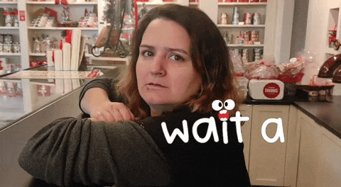 a woman leaning on a counter with the words wait a on her back
