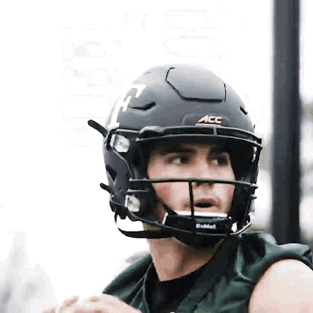 a football player wearing a black helmet with the letters acc on it
