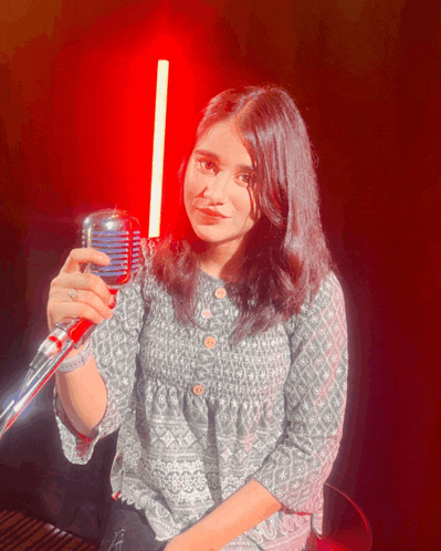 a woman holding a microphone in front of a red background