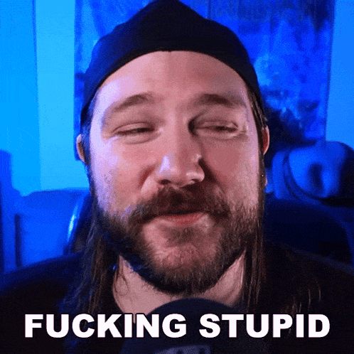 a man with a beard is wearing a black hat and has the words fucking stupid written on his face