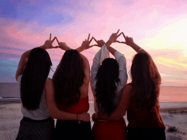 a group of girls making a triangle with their hands