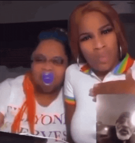 a woman with a pacifier in her mouth is sitting next to another woman .