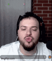 a man with a beard and headphones is blowing a kiss .