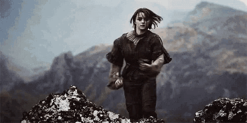 a woman is running on a rocky hillside in the mountains