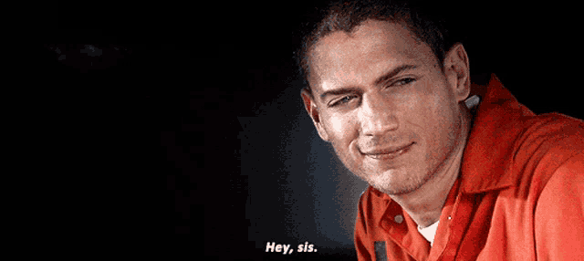 a man in an orange shirt is smiling and says hey sis