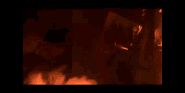 a close up of a fire in a dark room with a black background
