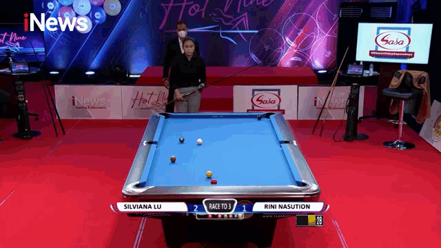 a pool table with a woman holding a cue and a sign that says inews