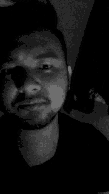 it is a black and white photo of a man with a beard .