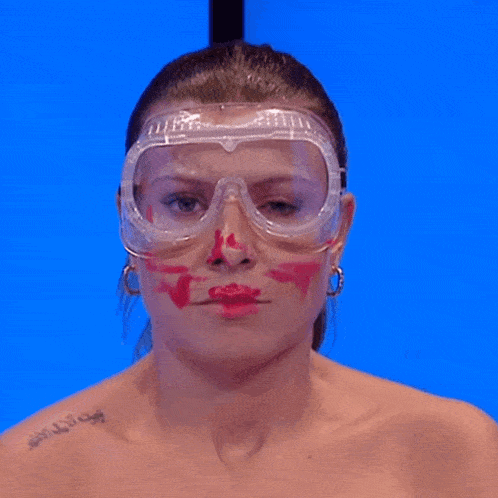 a woman with red lipstick on her face and goggles on