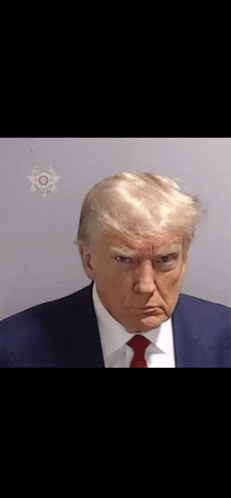 a man in a suit and tie is making a funny face in a jail cell .