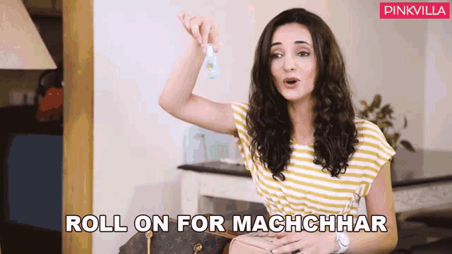 a woman in a yellow and white striped shirt is holding a small bottle and says roll on for machchhar