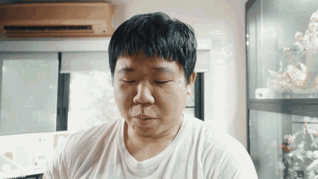 a man wearing a white shirt is looking down at something