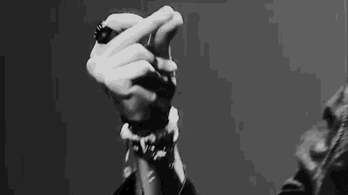 a close up of a person 's hand making a heart shape with their fingers .