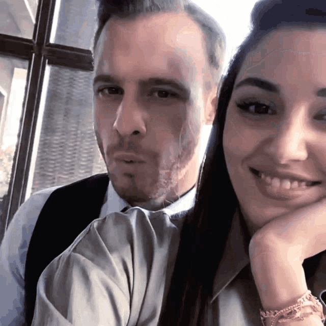 a man and a woman are posing for a picture and smiling