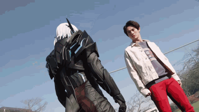 a man in a white jacket is standing next to a robot in a black suit
