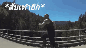 a man in a black tank top is running on a bridge with trees in the background and the words " * sb " in white letters