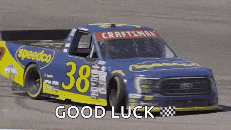 a blue and yellow race car with the number 38 on it is driving down a race track .