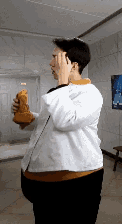 a man in a white jacket holds a stuffed animal in his hands