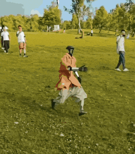 a man wearing a mask and gloves is running in a grassy field