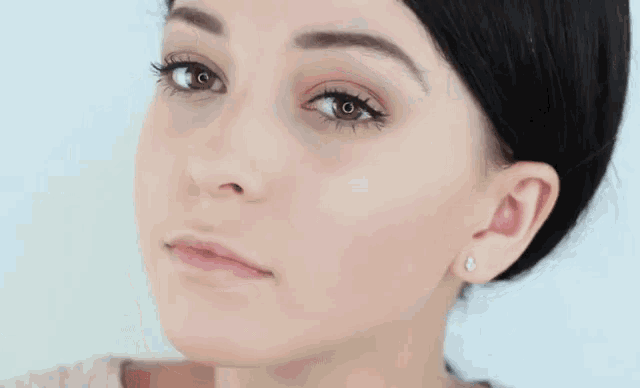 a close up of a woman 's face with earrings on