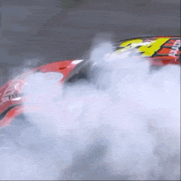 a red race car with the number 24 on the side is smoking