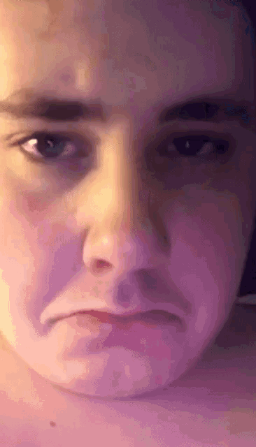 a close up of a person 's face with a sad look on their face