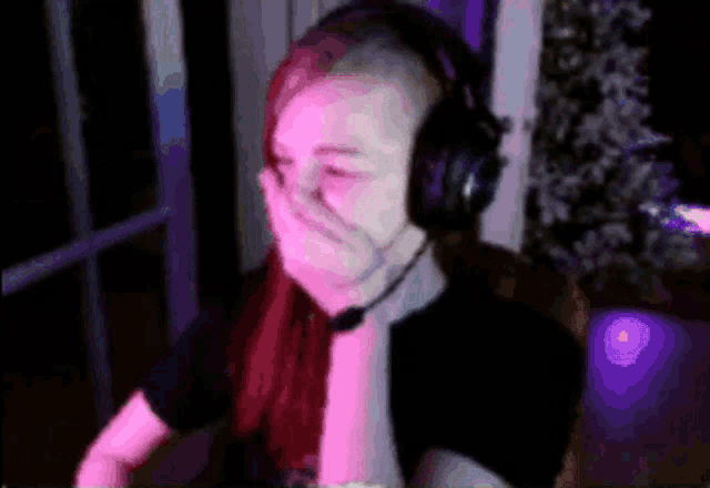 a woman wearing headphones and a microphone covering her mouth