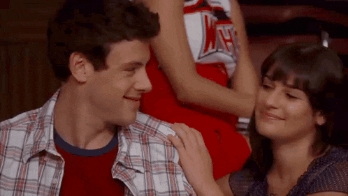 a man and a woman are sitting next to each other .