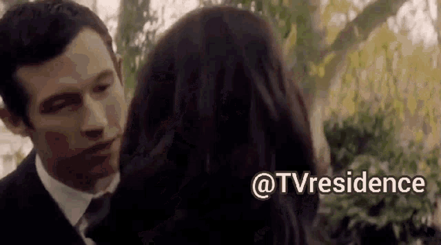 a man in a suit and tie is kissing a woman with the words @tvresidence written above them