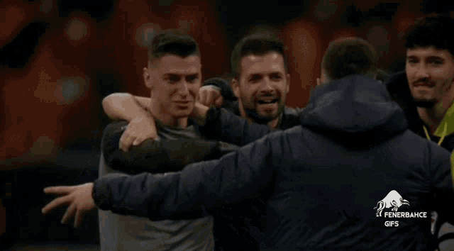 a group of men hugging each other with the word fenerbahce on the back of their jacket