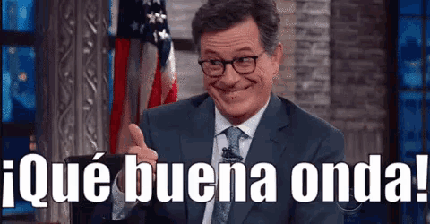 a man in a suit and tie is giving a thumbs up and says que buena onda